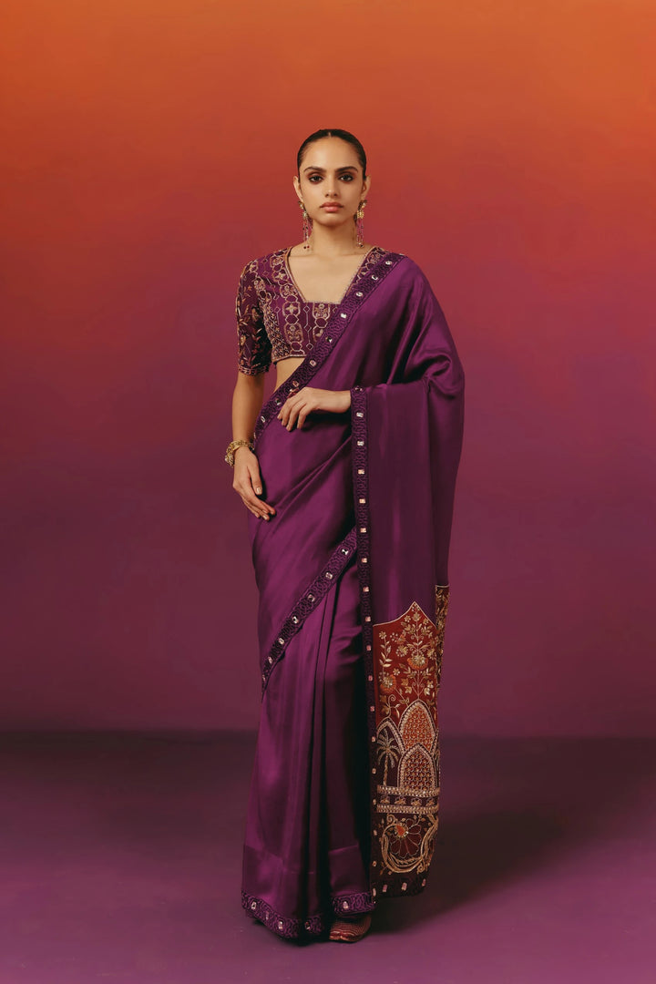 Front view of a model in Warra's purple silk saree with an embroidered V-neck blouse, statement drop earrings and a gold cuff bracelet