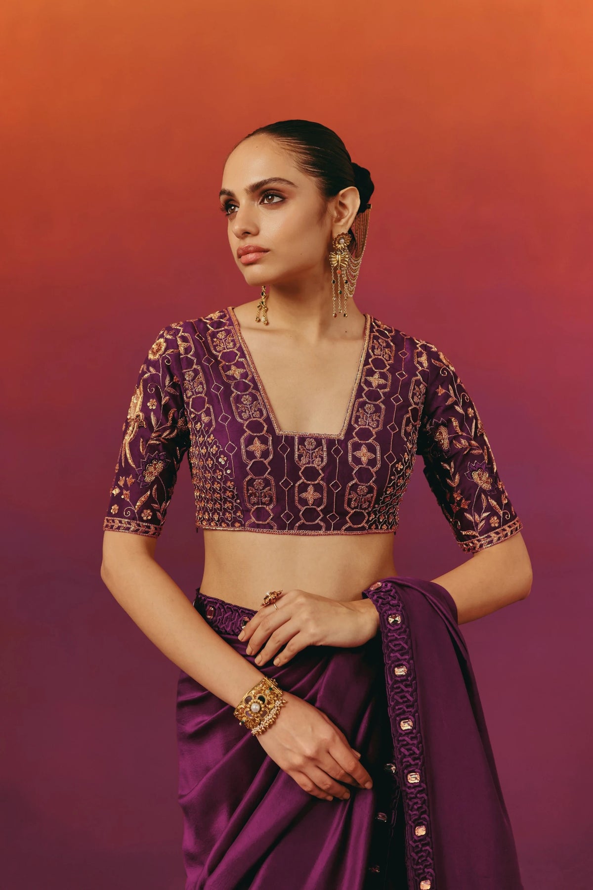 Back view of a model in Warra's purple silk saree, showing the hand-embroidered geometric blouse and the pallu falling over one shoulder
