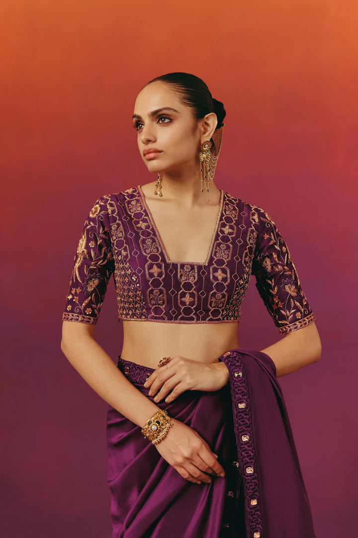 Back view of a model in Warra's purple silk saree, showing the hand-embroidered geometric blouse and the pallu falling over one shoulder