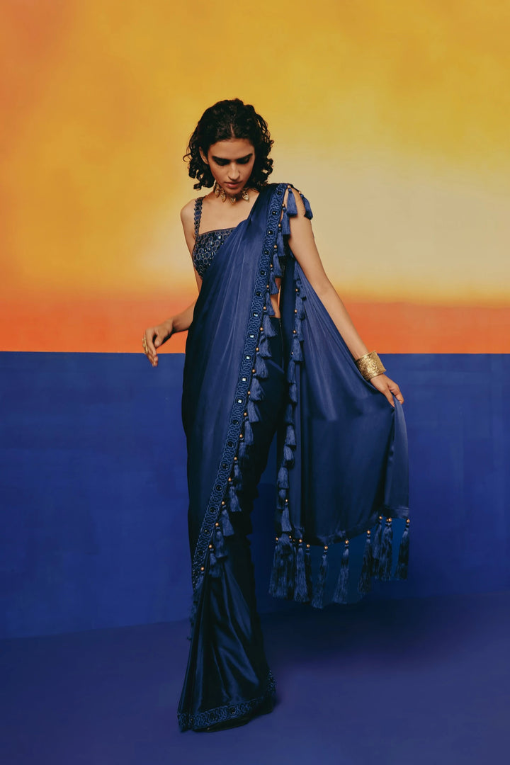 Front view of a model walking in Warra's Crystal Blue Tassel Saree, the tasseled crystal-bordered pallu caught in motion