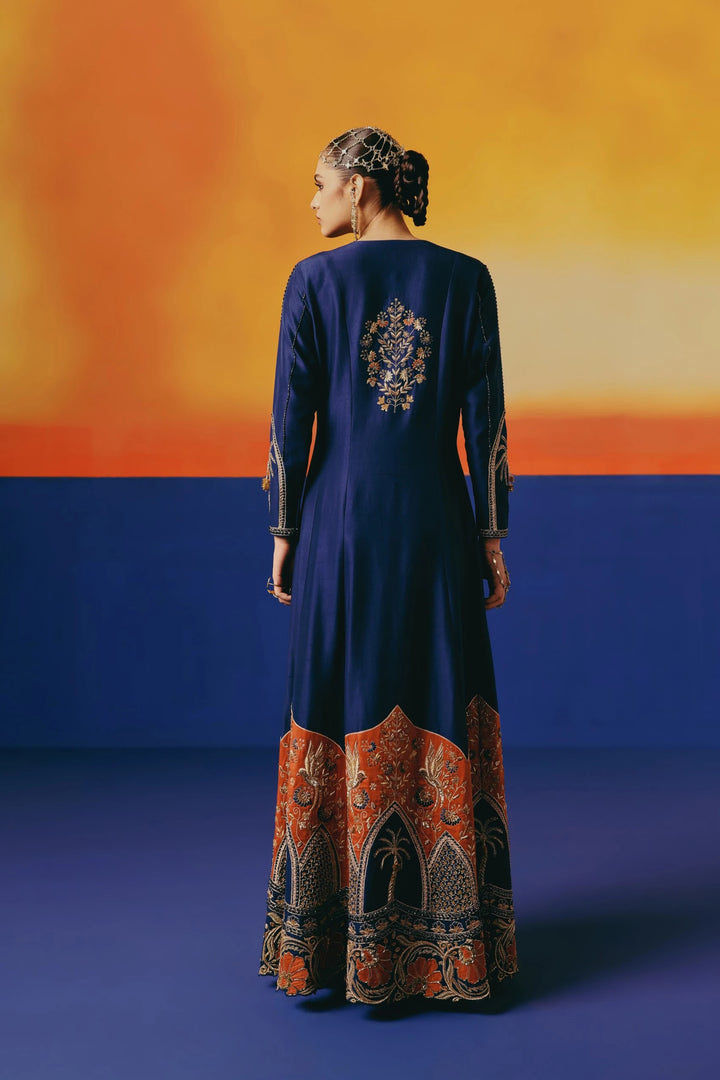 Back view of Warra's navy silk anarkali showing a hand-embroidered floral medallion below the neckline and an orange-and-gold palm tree hem border