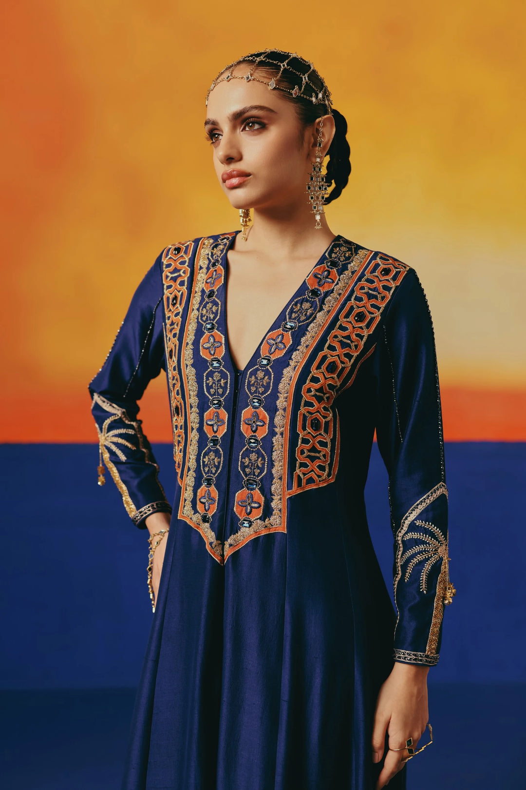 Close-up of the embroidered yoke on Warra's navy silk anarkali showing an orange-and-navy geometric trellis pattern with jewelled buttons down the front