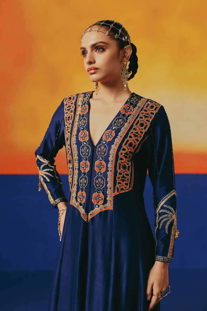 Close-up of the embroidered yoke on Warra's navy silk anarkali showing an orange-and-navy geometric trellis pattern with jewelled buttons down the front