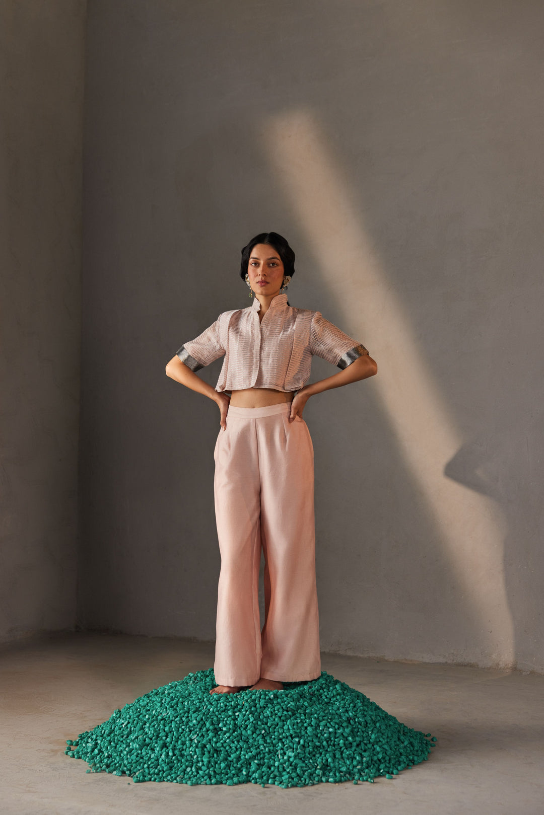 A woman wearing a powder pink chanderi zari top with pleats and matching flared palazzo pants.